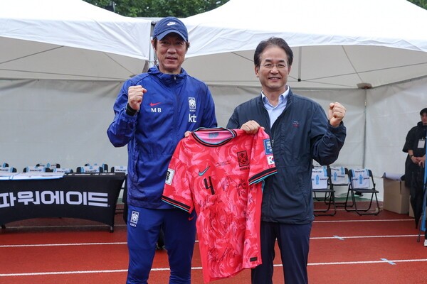 국가대표팀 선수들의 친필 사인 유니폼을 들고 기념촬영 중인 이동환 고양특례시장(오른쪽)과 홍명보 축구 국가대표팀 감독(왼쪽)